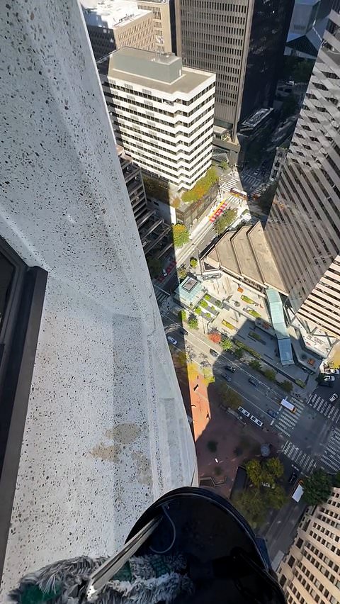 Window cleaner works at considerable height on building exterior