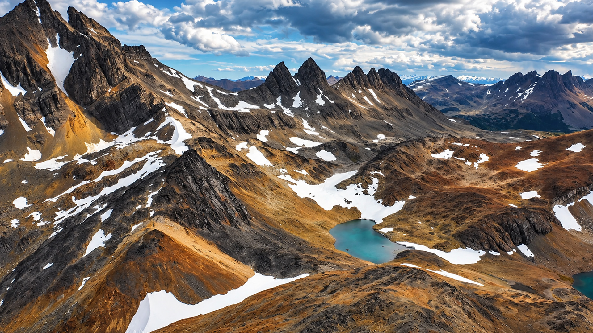 Un pequeño lago azul bajo picos escarpados y elevados