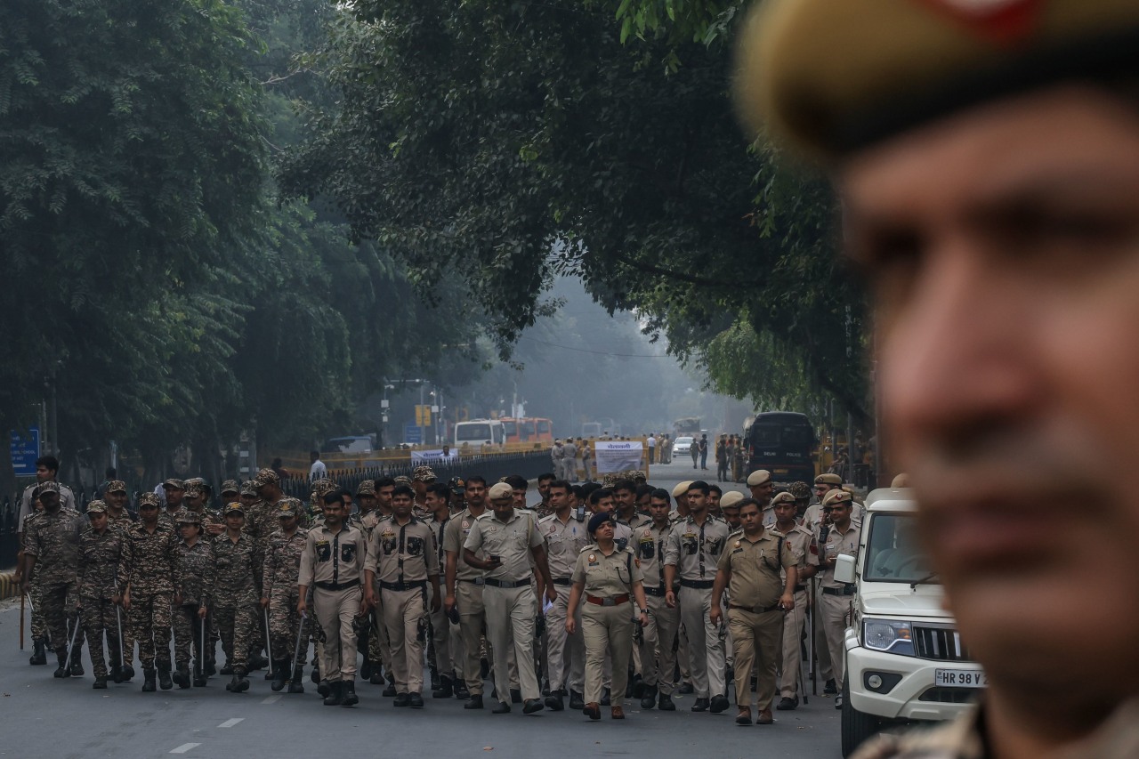 Indian police personnel stand guard.