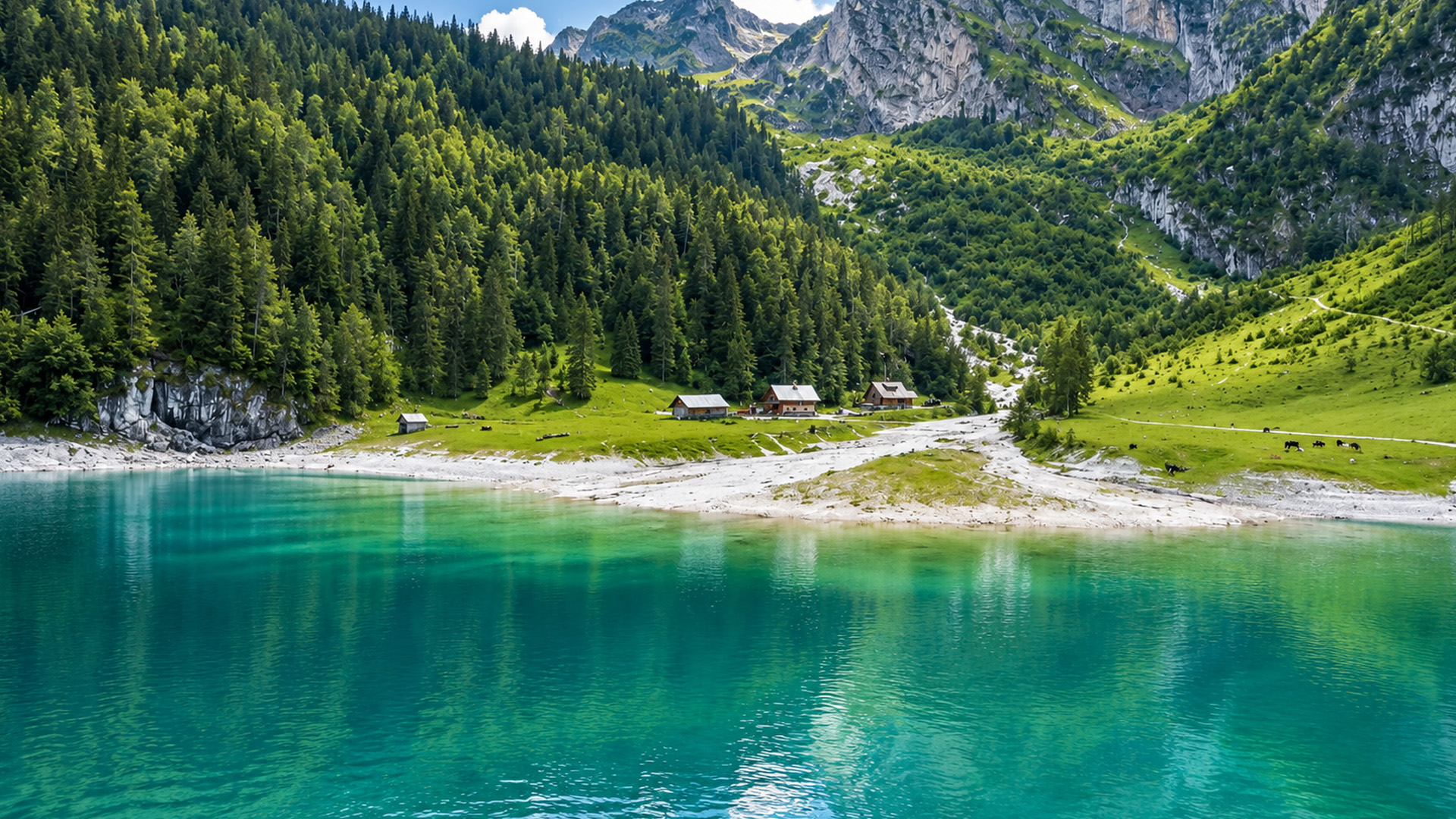 Pequeñas cabañas de montaña junto a un enorme lago alpino