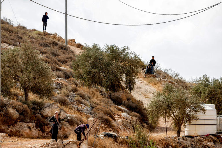 De jeunes colons israéliens surplombent des Palestiniens, en périphérie du village de d'Al-Mughayyir, en Cisjordanie, le 29 septembre 2026