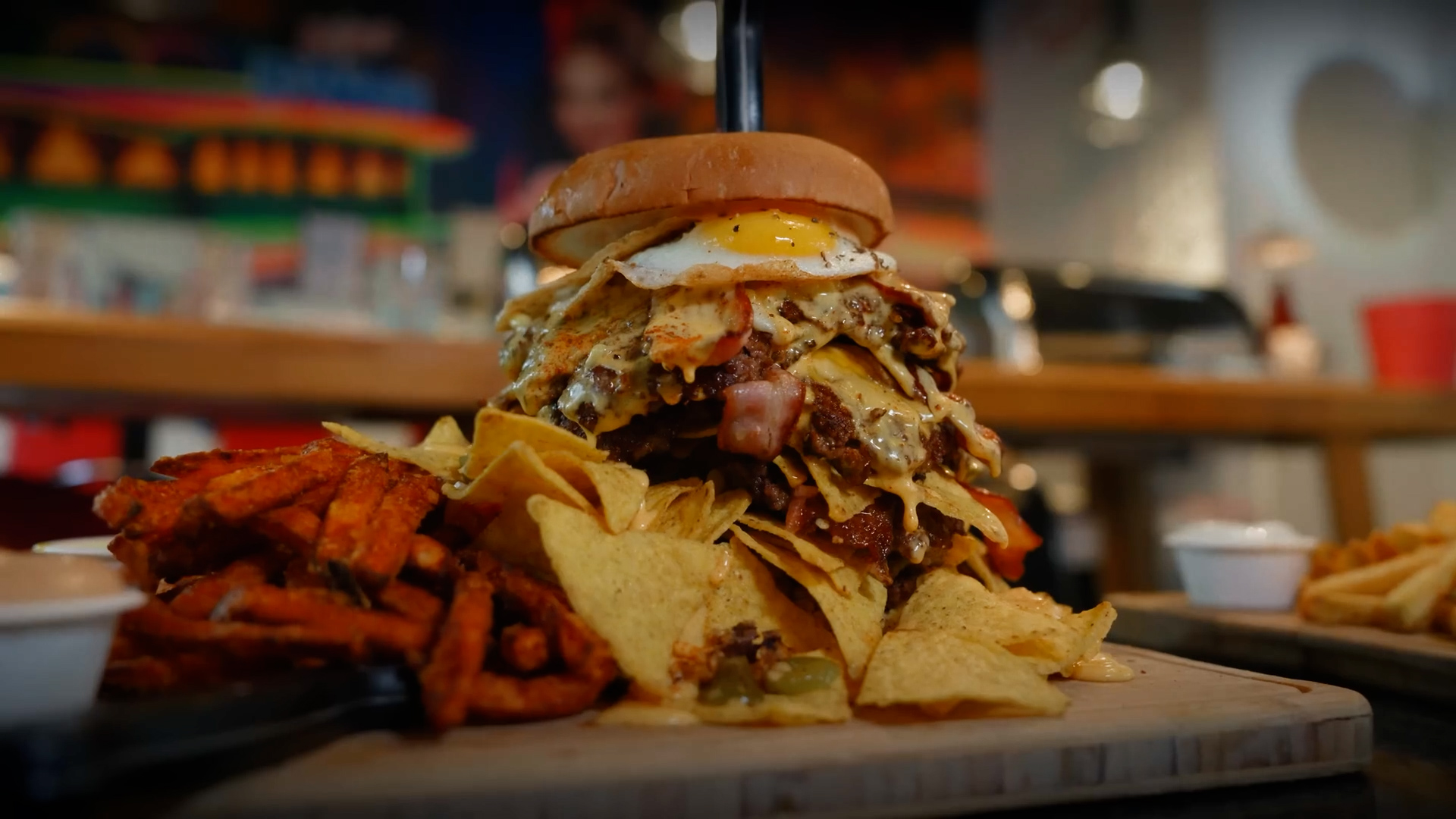 Man attempts impossible burger challenge loaded with nachos and cheese
