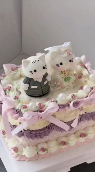 Adorable cat-themed cake is wrapped in pastel bows and flowers