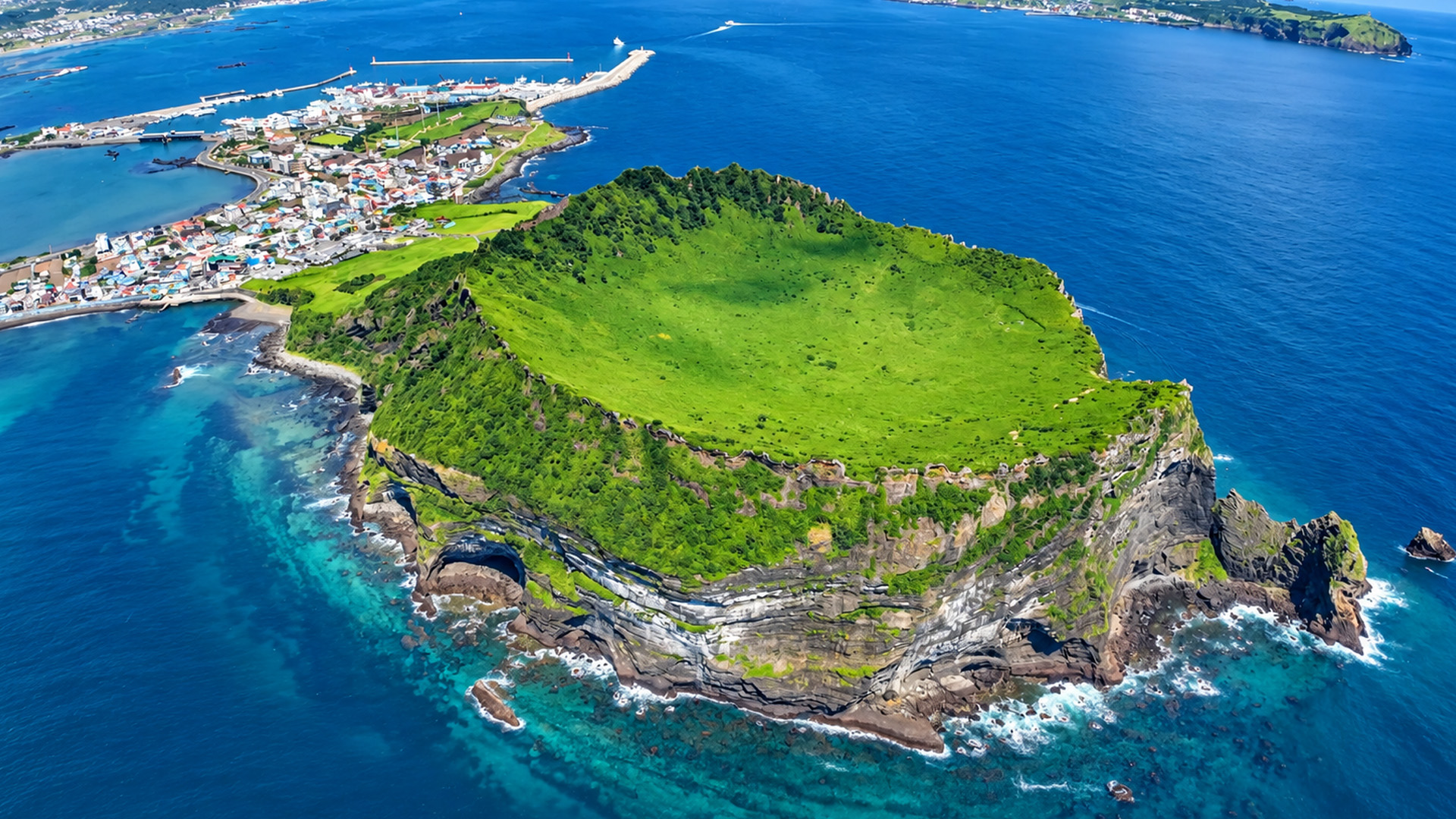 A coastal village sits beside an ancient crater