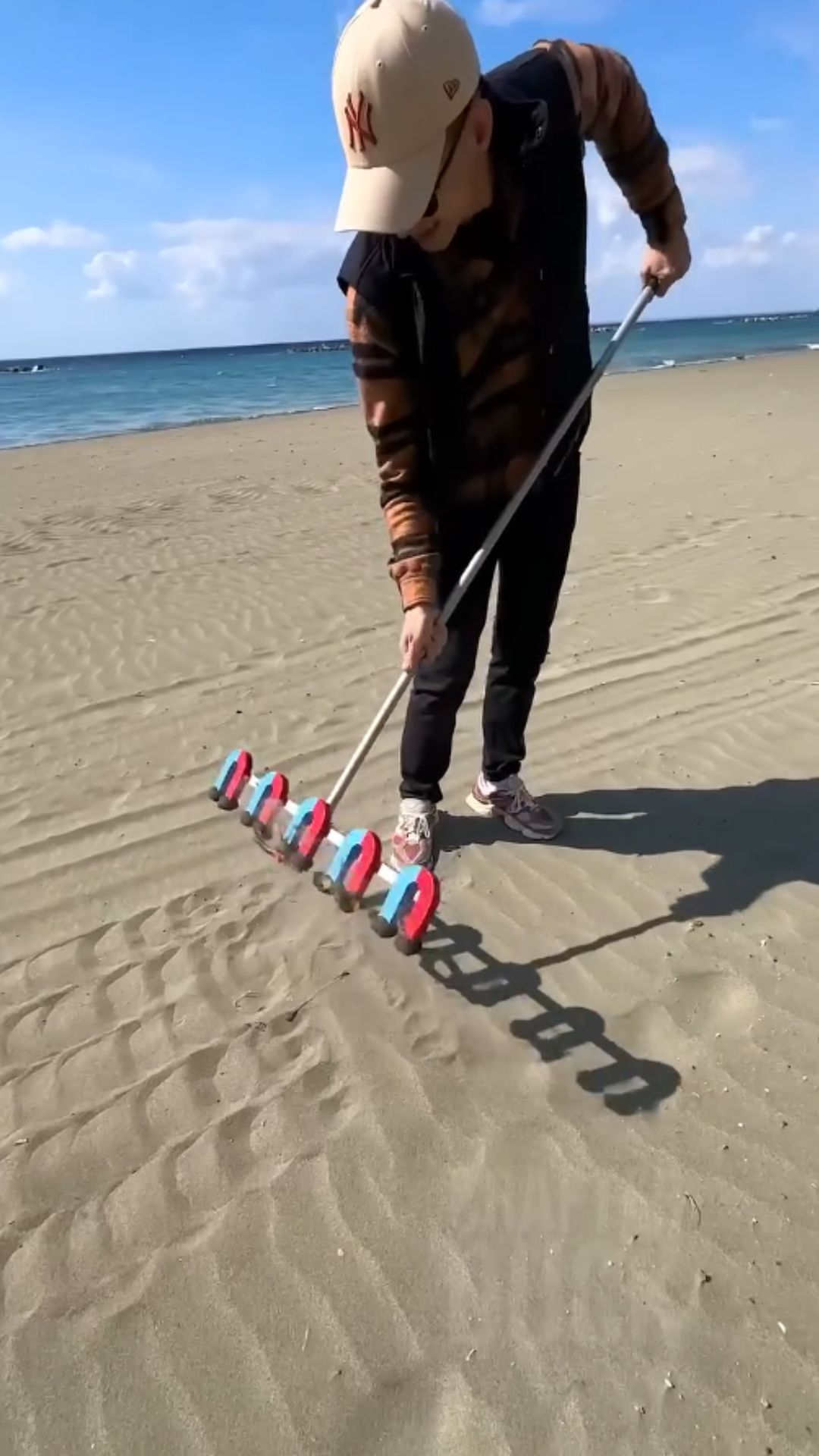 Magnetic rake uncovers hidden treasures beneath the sand