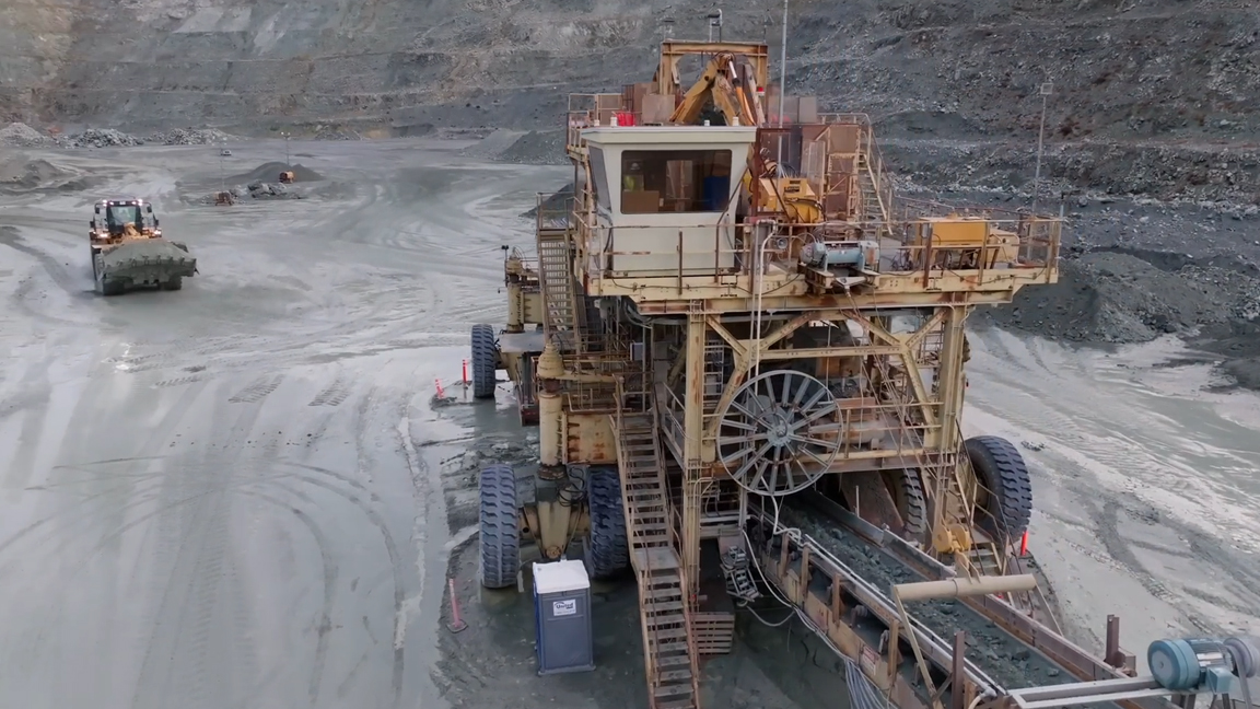 Giant mining machine processes material inside a massive open-pit mine