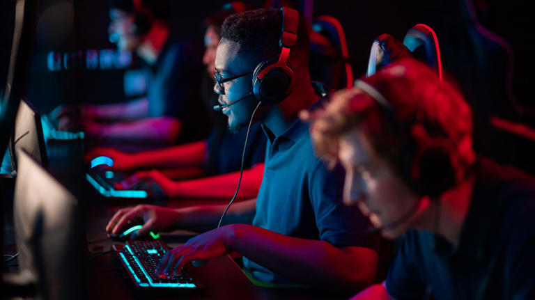 People sitting in a row playing PC games