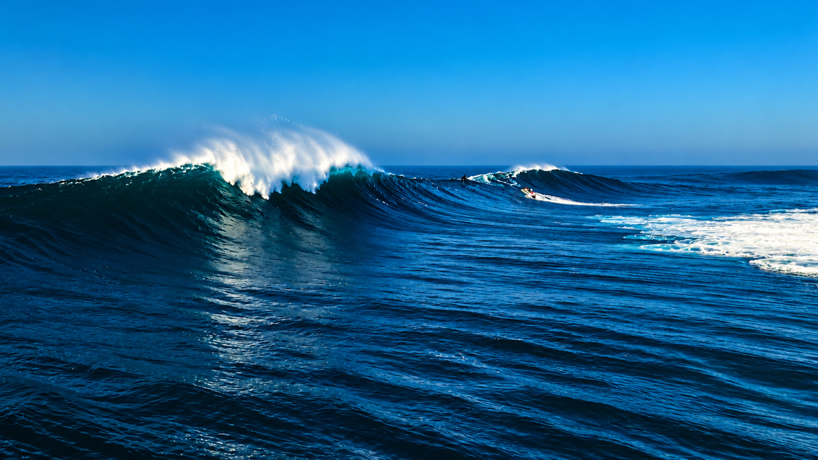 Powerful ocean swells rolling across the deep blue sea