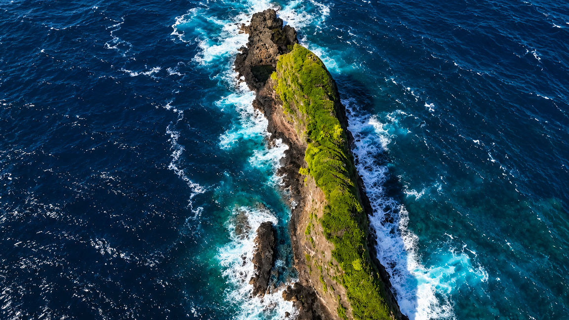 Hidden green ridge surrounded by the deep blue ocean