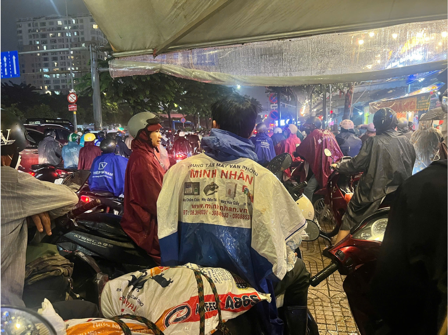 Người phụ đạp xe, chỉ đường, người có cái áo mưa cũ cho nè khi trời mưa kẹt xe, ngập nước