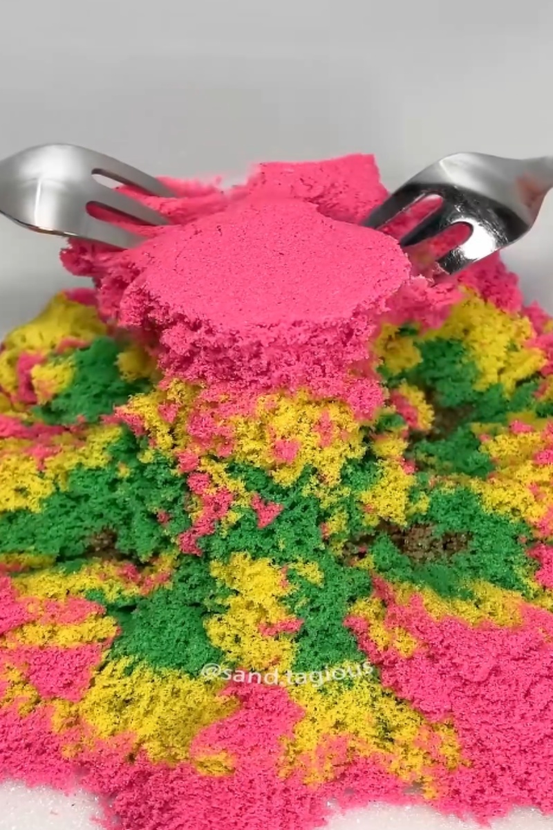 Colorful kinetic sand crushed with forks