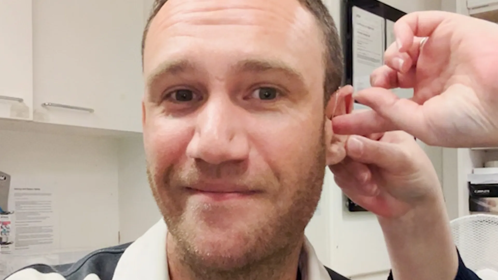 Man's emotional reaction after trying on hearing aid for the first time