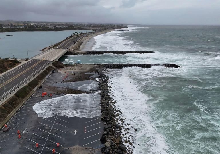 Waves break onto the parking lot at Tamarack State Beach during a high tide as the remnants of Tropical Storm Rachel moved through the region on Oct. 11, 2026 in Carlsbad. (The San Diego Union-Tribune/The San Diego Union-Tribune via )