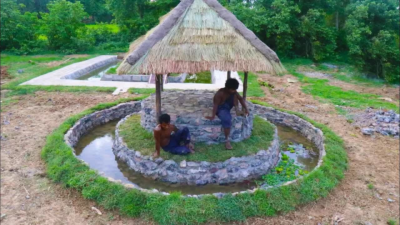 Watch these jungle builders craft a stone hut with a fish pond