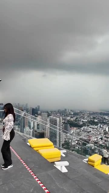 Tourists on top of skyscraper scatter as lightning strikes