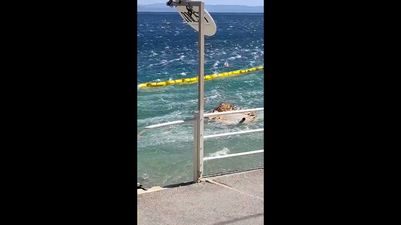 Violent meltemi wind gusts send beach furniture into sea
