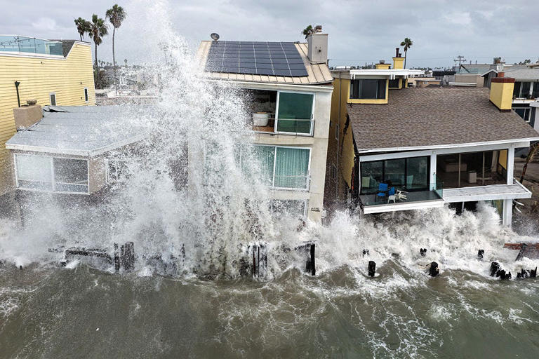 In an aerial view, Pacific Ocean waves wash into damaged homes amid high surf generated by Tropical Storm Rachel on Oct. 11, 2026 in Long Beach, California. California was under its second-ever tropical storm watch, with coastal flood warnings in effect from Los Angeles to San Diego. An emerging El Niño and oceanic Kelvin wave moving up the coastline have compounded conditions in the region.