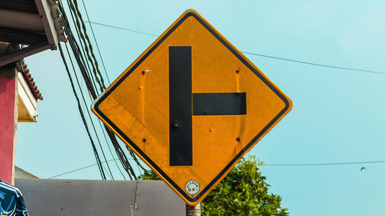 What does the yellow road sign with a black letter T on it mean?