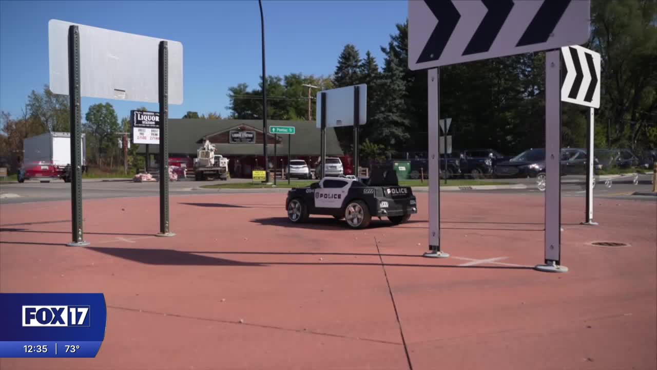Tiny toy police cruiser at roundabout slowing down real drivers