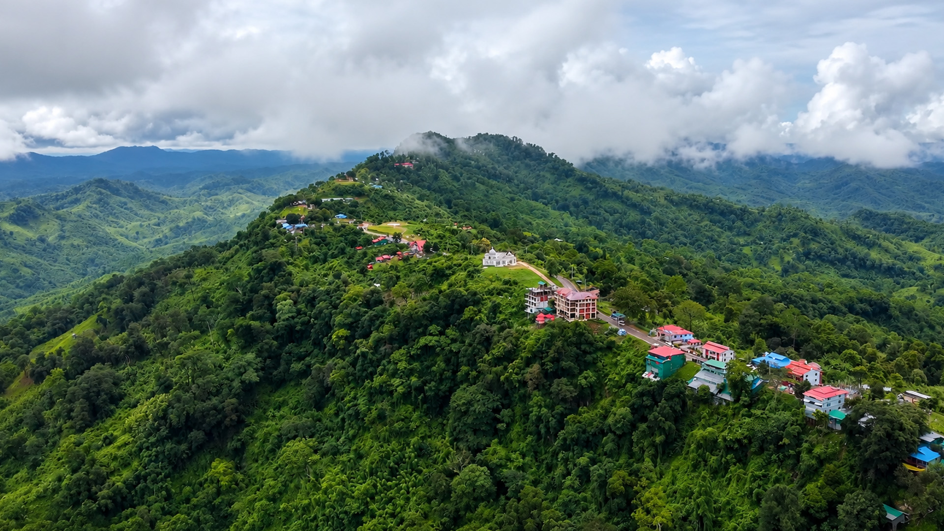 A narrow mountain ridge covered with houses and forest