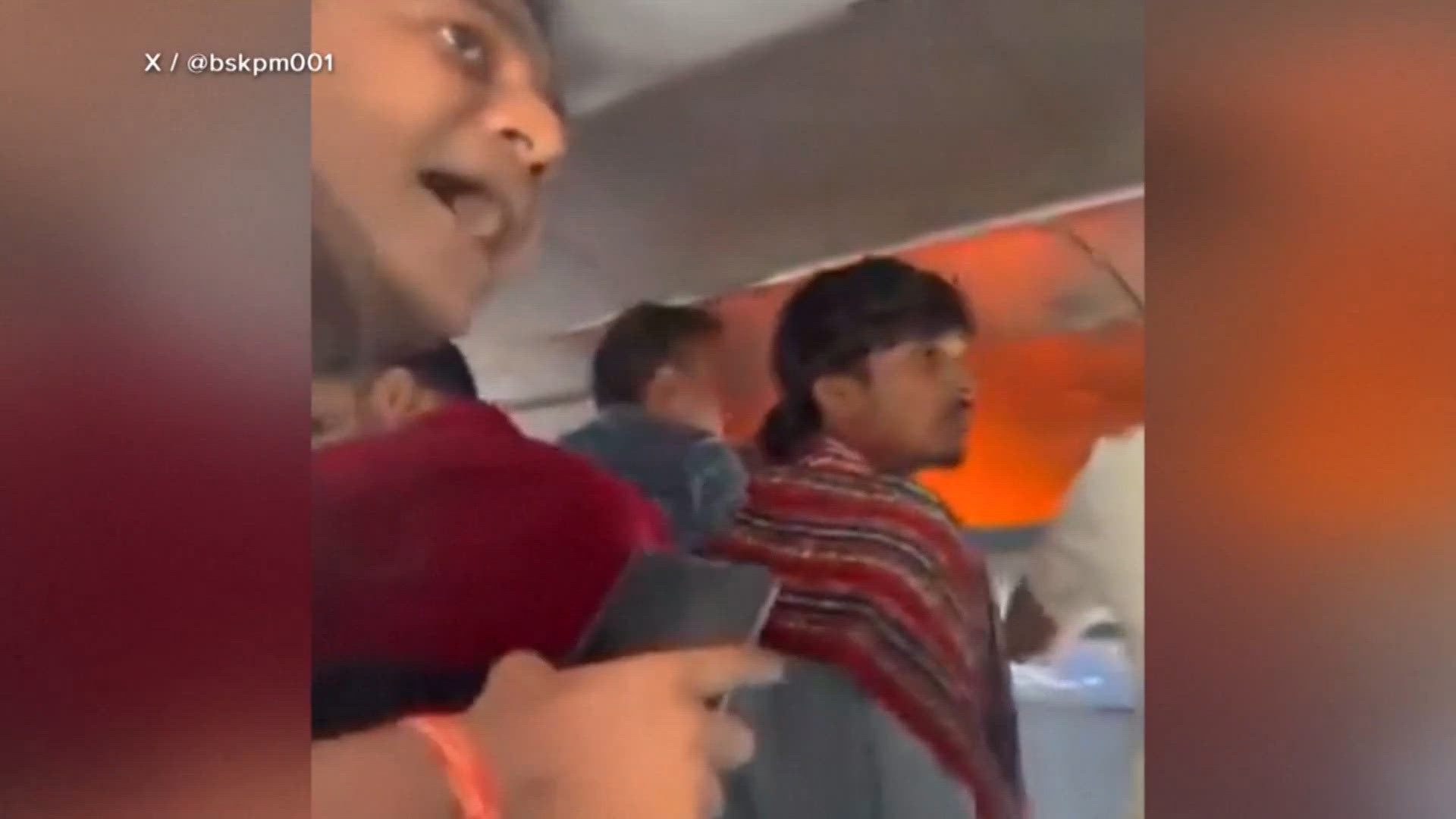 Passengers help extinguish a fire in an overhead bin