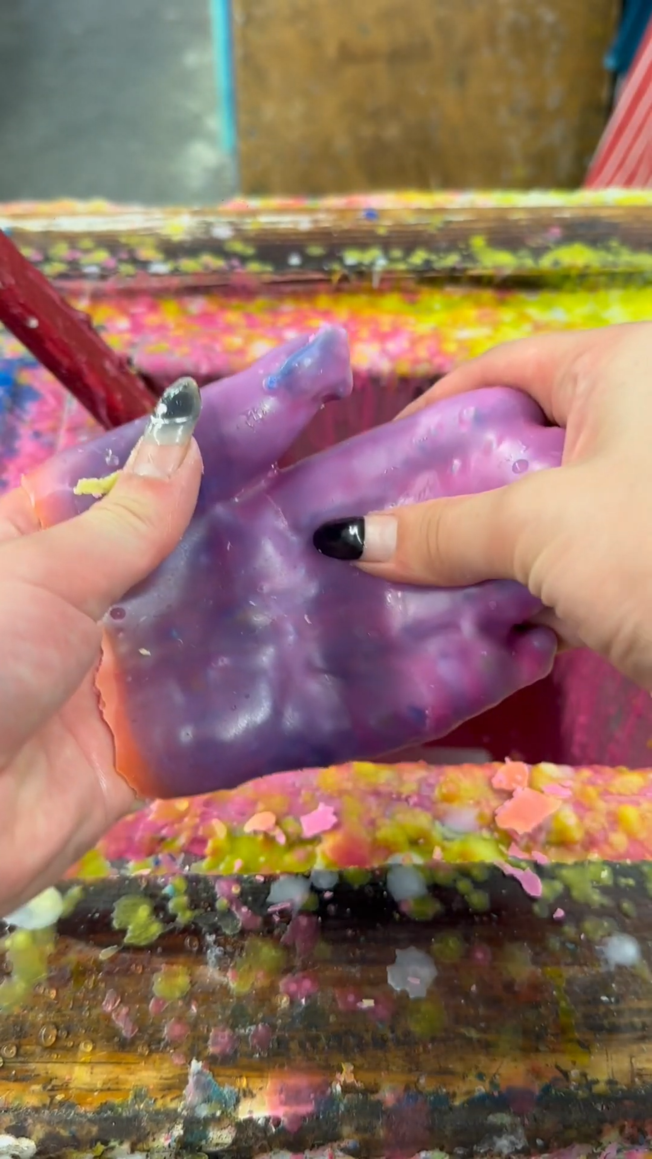 Breaking a hand shaped wax creation into pieces