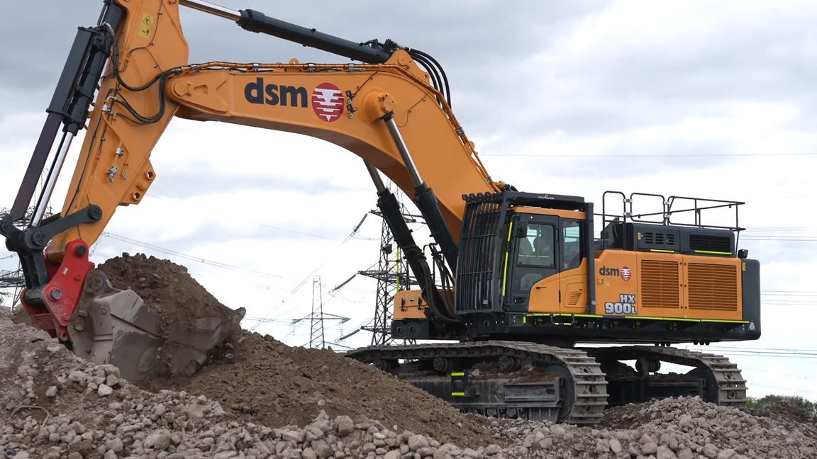 Massive 90-ton excavator digging through huge piles of rocks and dirt