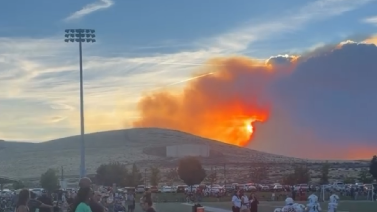 Hawk fire spreads on hillside beside youth football field