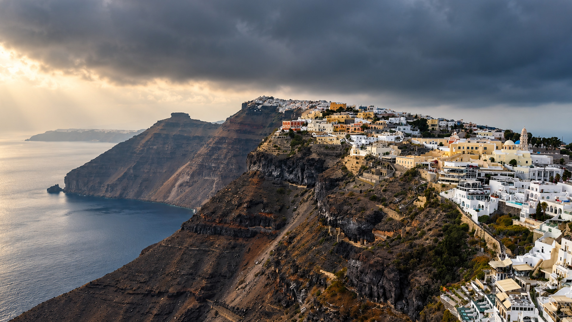 White buildings crowded along the edge of a volcano