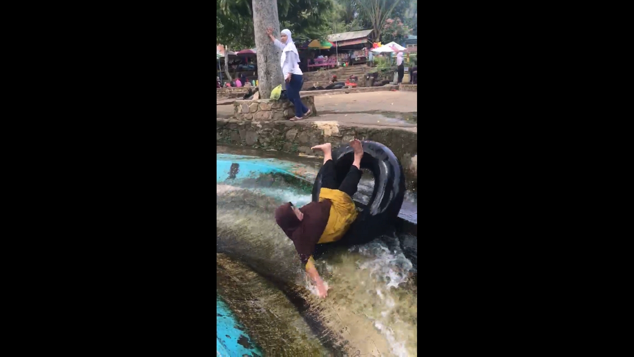 Mother falls off inflatable ring while sliding into pool