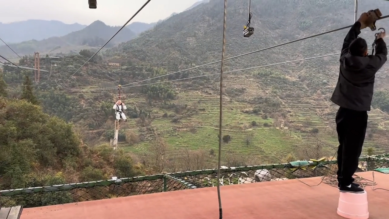Man pauses mid-zipline during Zhejiang mountain climb