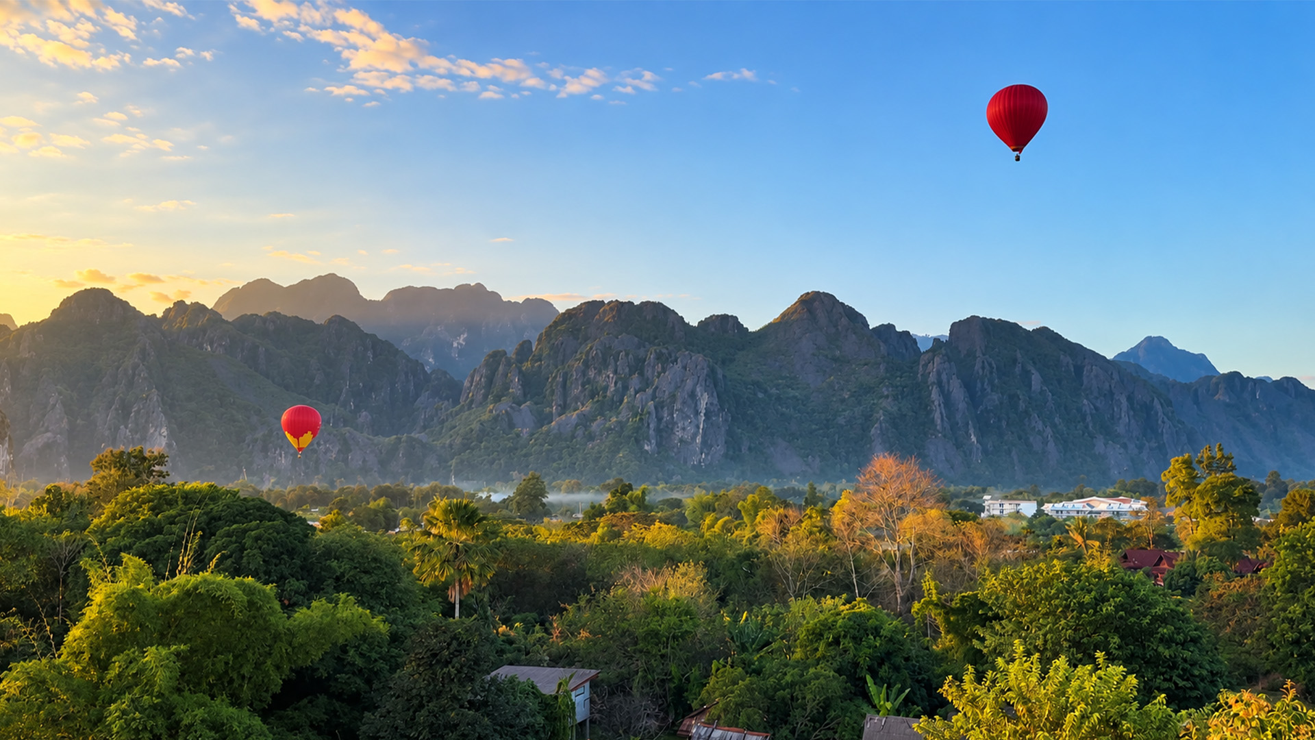 Hot air balloons above Vang Vieng’s limestone mountains
