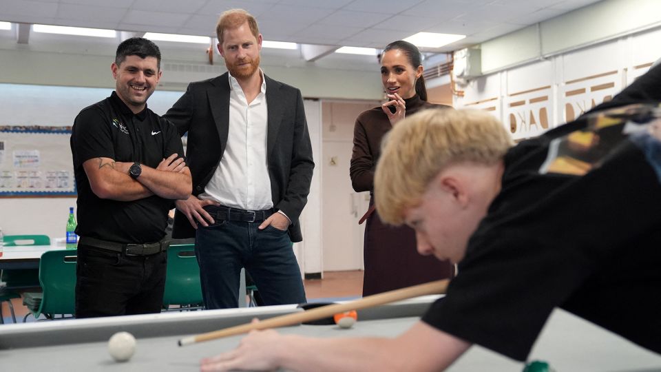 Harry and Meghan watch a game of pool during a visit to Epic Partners in Nottingham. - Joe Giddens/Reuters