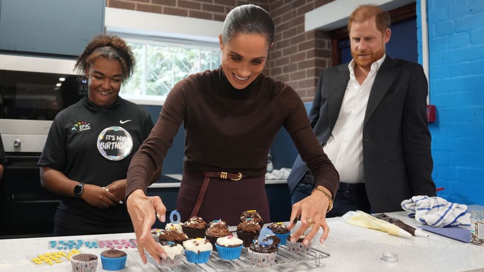 Meghan arranges birthday cupcakes during a visit to Epic Partners. - Joe Giddens/Reuters