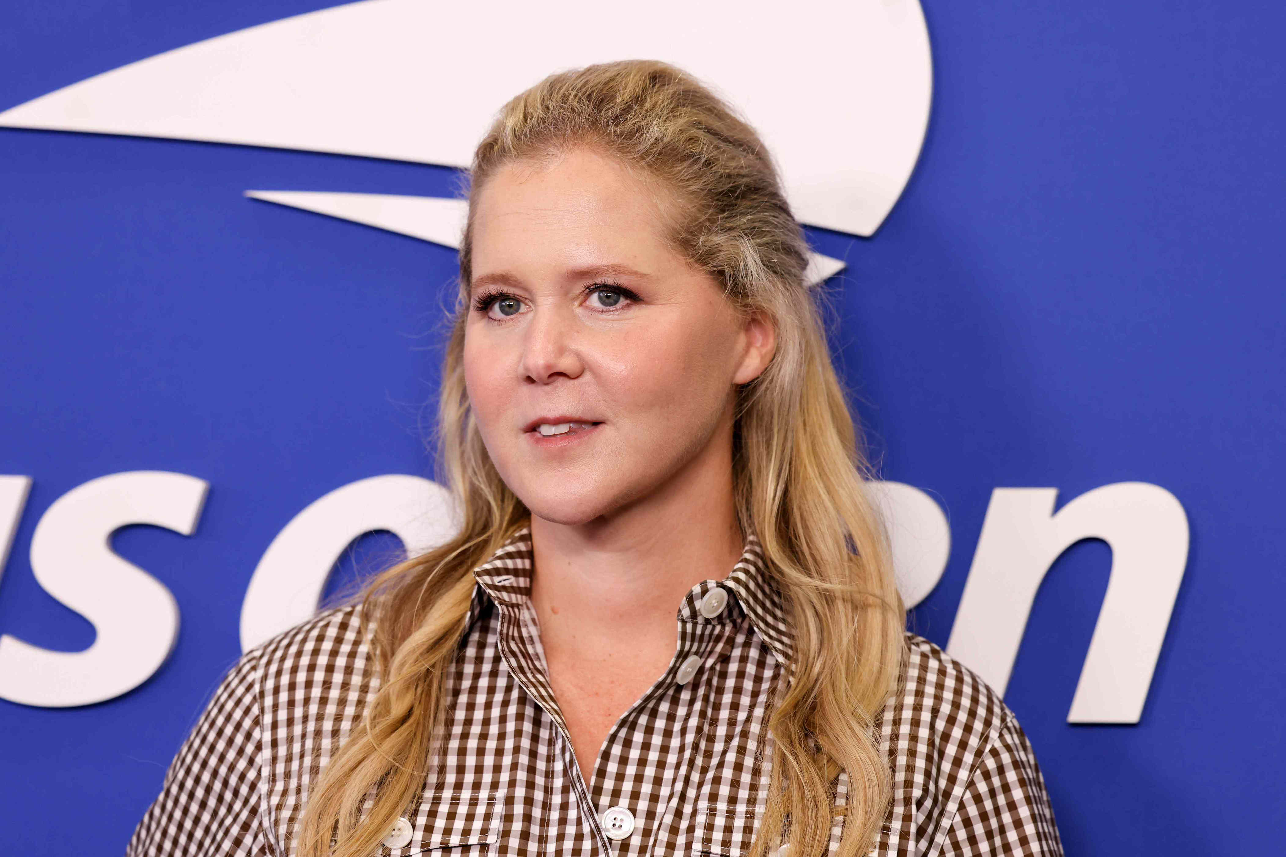 Amy Schumer rocks a strapless black swimsuit with her natural hair to ...
