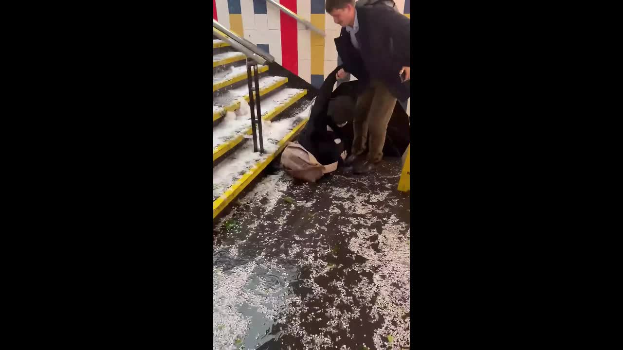 Commuter slips on hail-covered stairs at Salvador Metro Station in ...