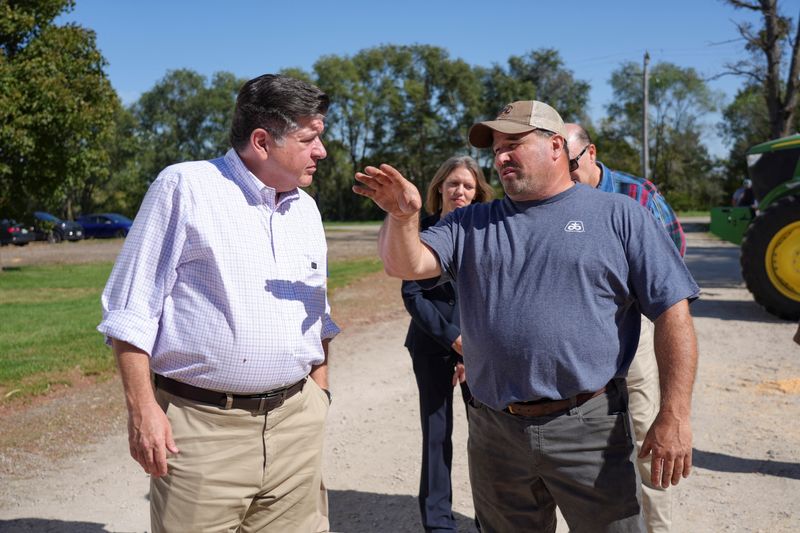 Illinois Governor JB Pritzker, who is running for a third term and has been eyed as a possible Democratic contender for the White House in 2028, speaks to a farmer in Gardner, Illinois, US, October 7, 2026. REUTERS/Eric Cox