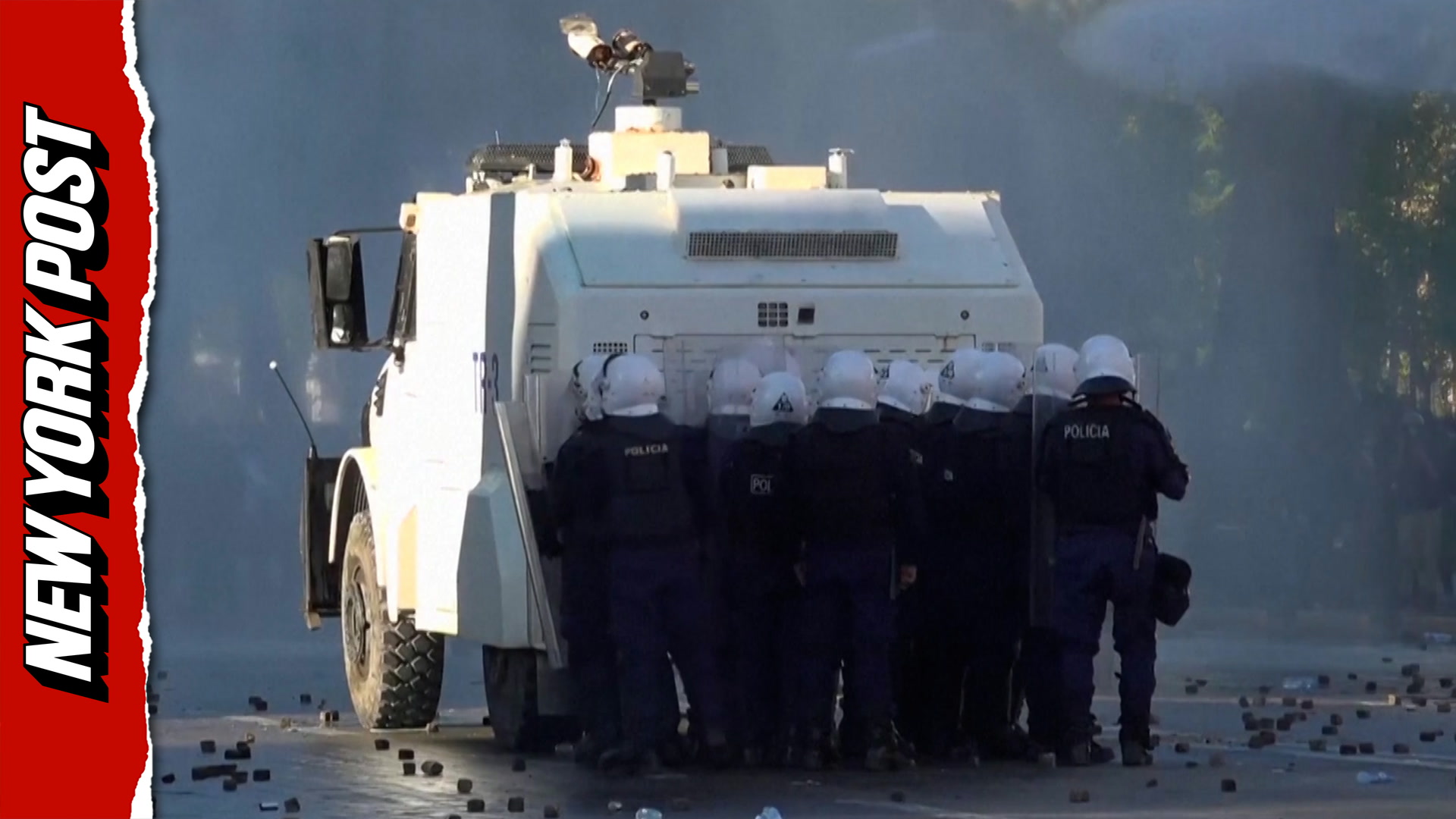 Albanian riot police take cover behind water cannons as angry student ...