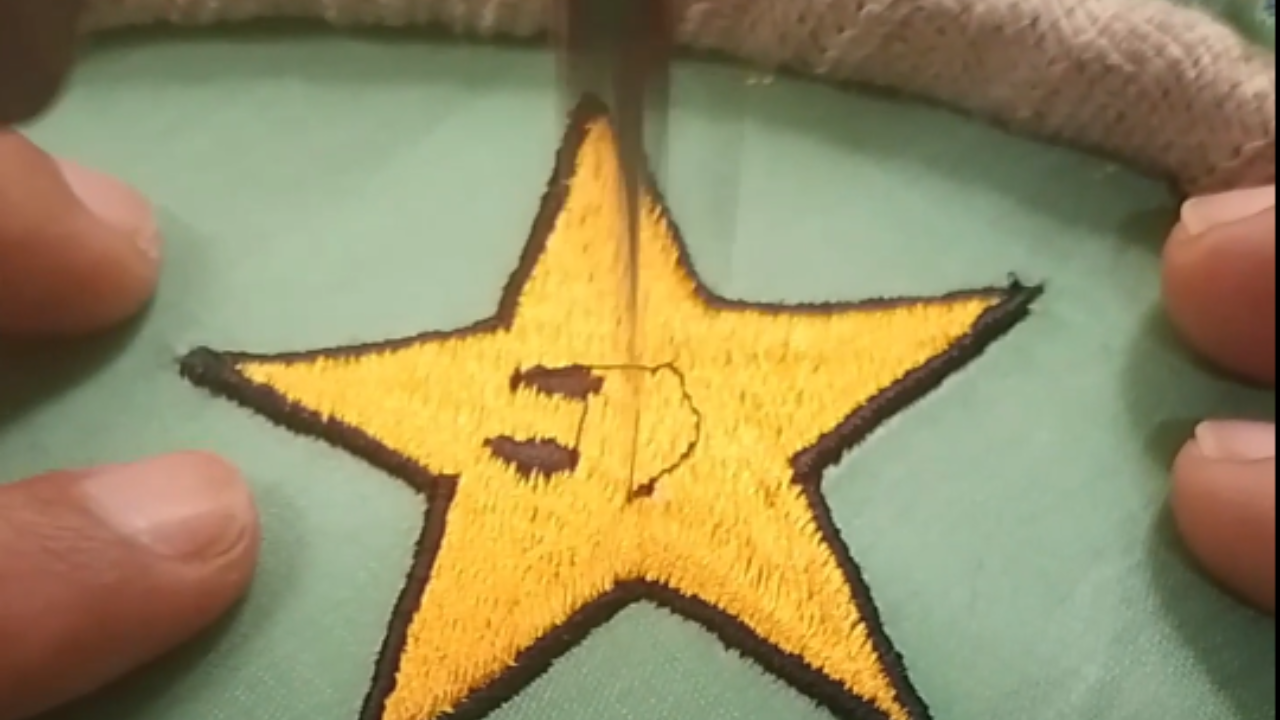 Craftsman uses machine to embroider star with cute face