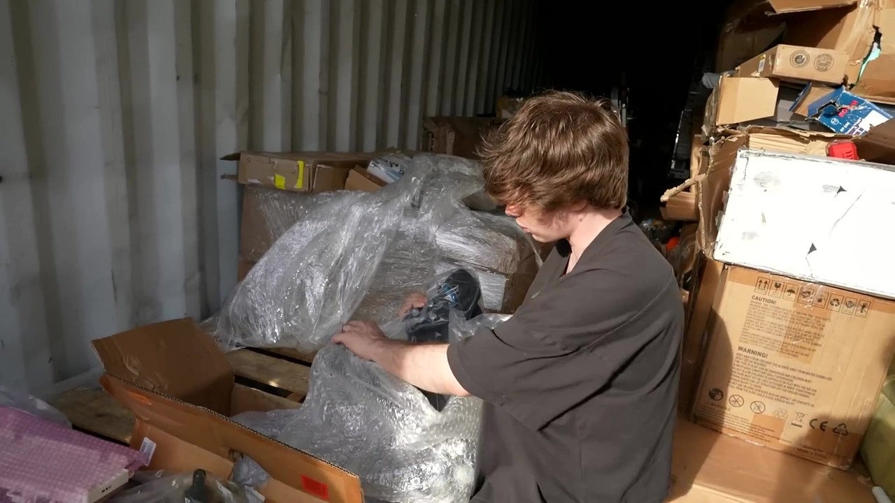 Connor opens a shipping container of Amazon returns from Hong Kong