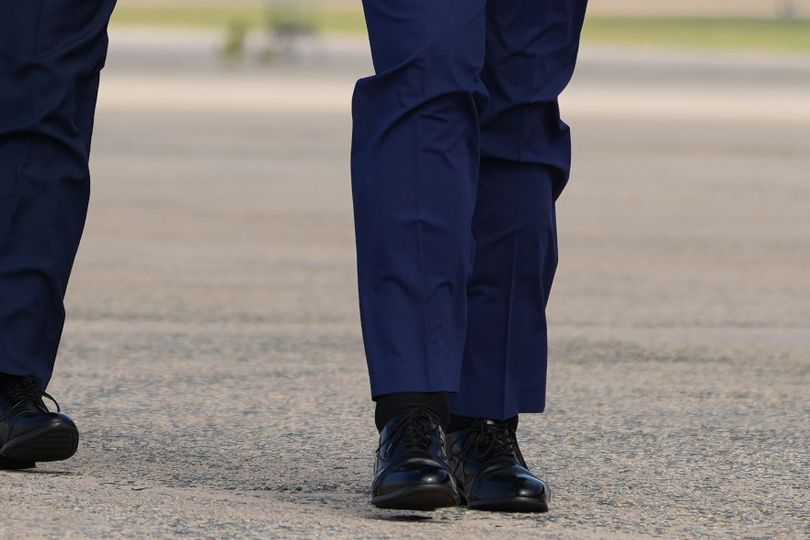 Trump appears to be wearing 'bionic legs' as he staggers across tarmac ...