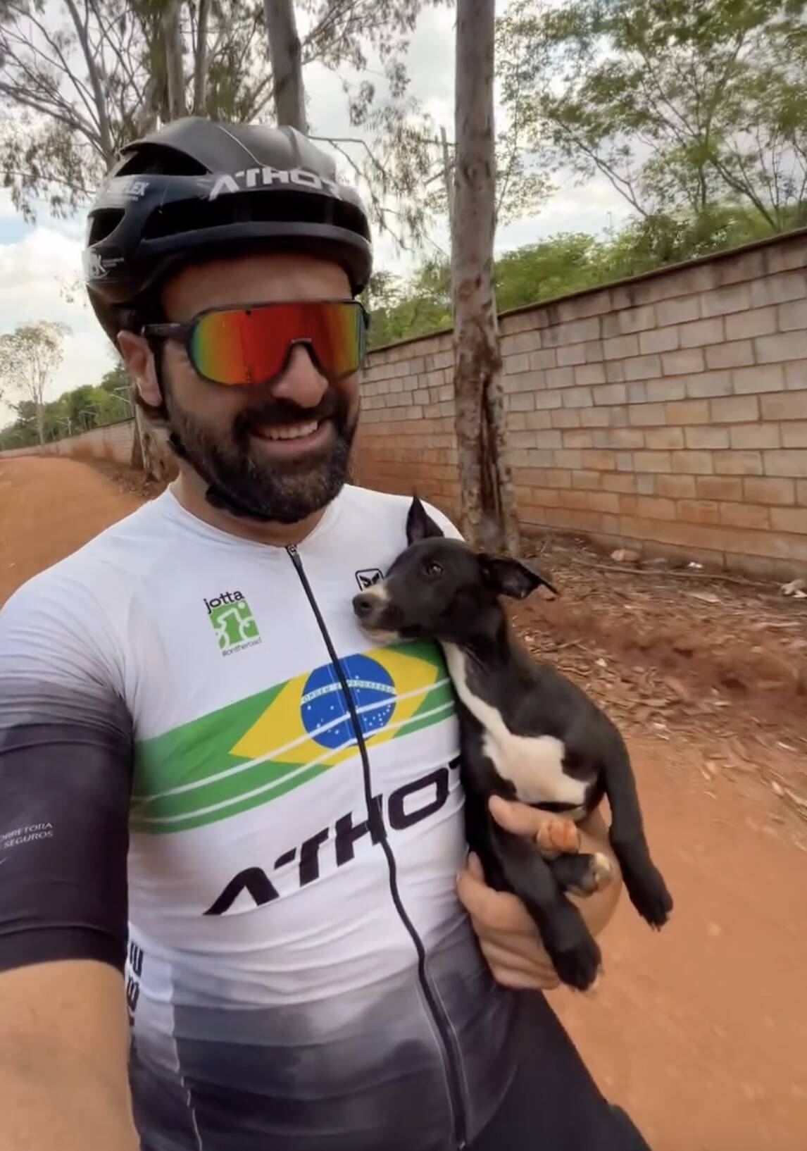 Puppy stranded alone on roadside shows his belly to cyclist who stops to help