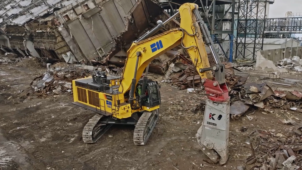 Massive excavator with powerful hydraulic shears demolishing industrial ...