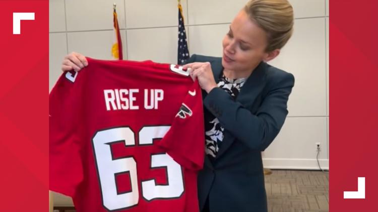 Mayor Helena Moreno receives Falcons jersey after losing bet