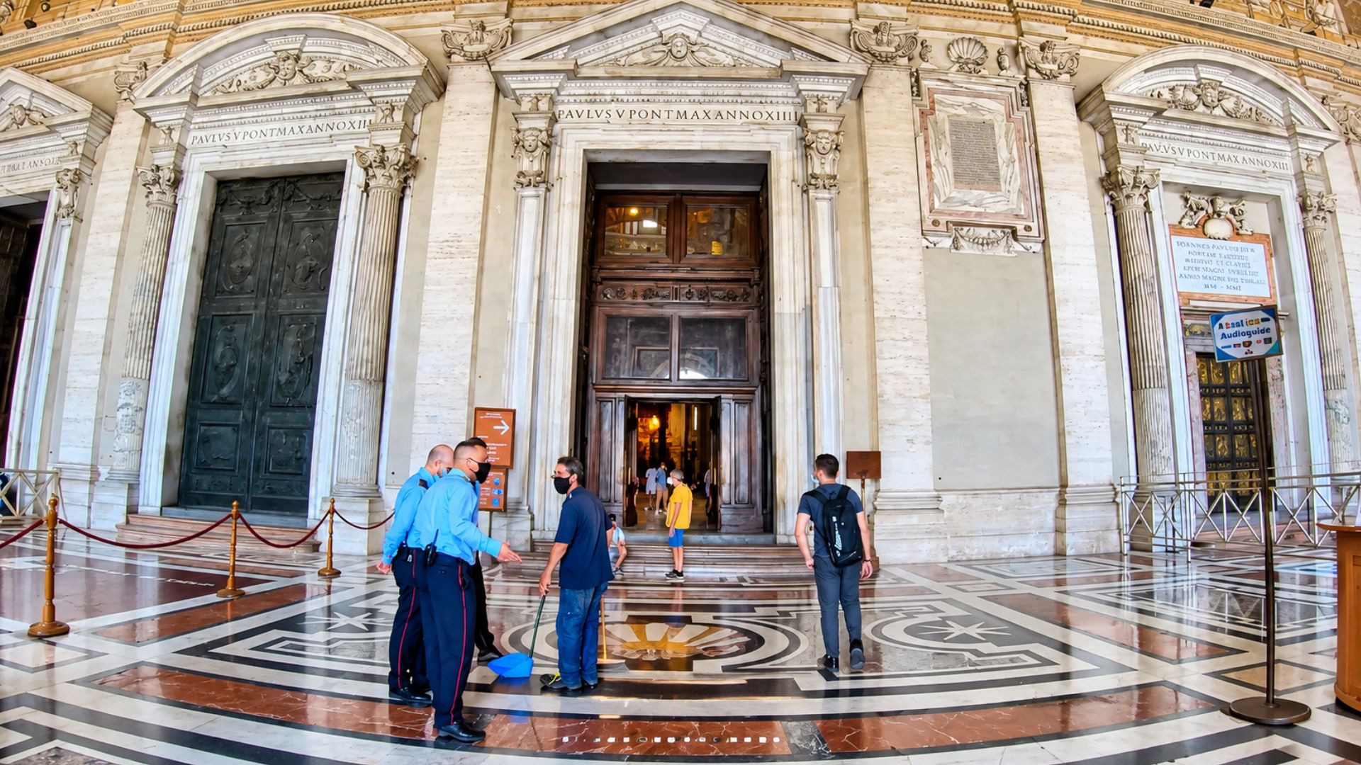 What awaits visitors beyond these massive doors at the Vatican?