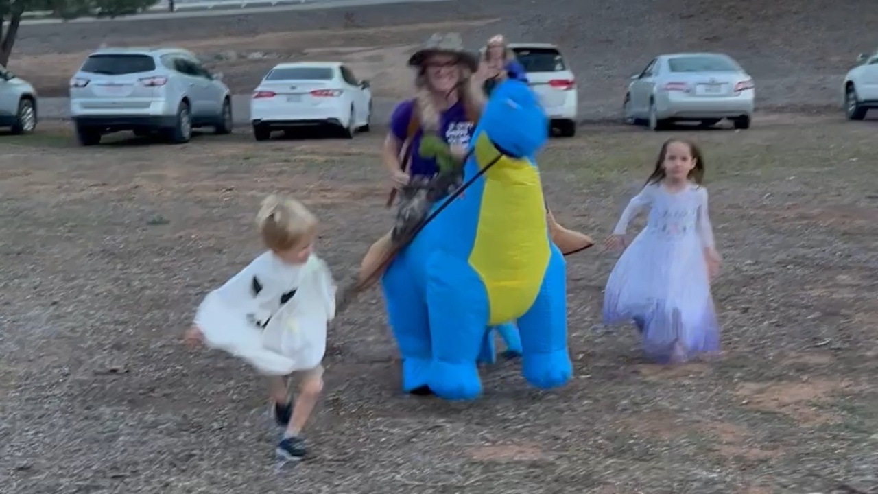 Little boy tumbles while leading mom's inflatable dinosaur