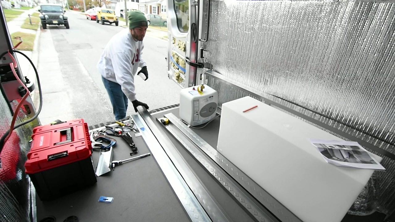 A couple builds a sprinter van camper on the side of the road