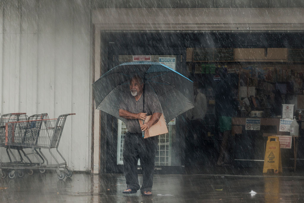 A resident carries supplies during Hurricane Lala in Hawaii - Photo Credit: Getty