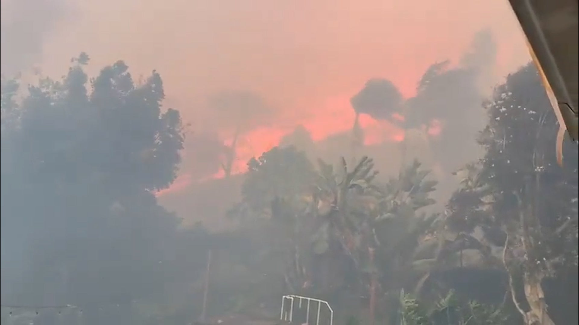 Thousands evacuate Southern California as wind-fueled fires burn homes