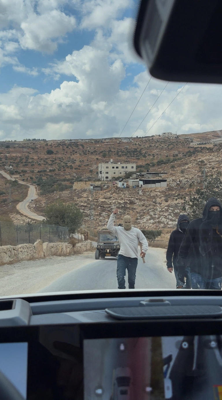 Masked people at the site where Belgium's foreign minister says masked settlers attacked Palestinians, Catholic representatives and Western diplomats and officials in Taybeh, in the Israeli-occupied West Bank, on Oct. 17, 2026 in this screengrab from a video obtained from social media. / Credit: Amit Orfali/via REUTERS